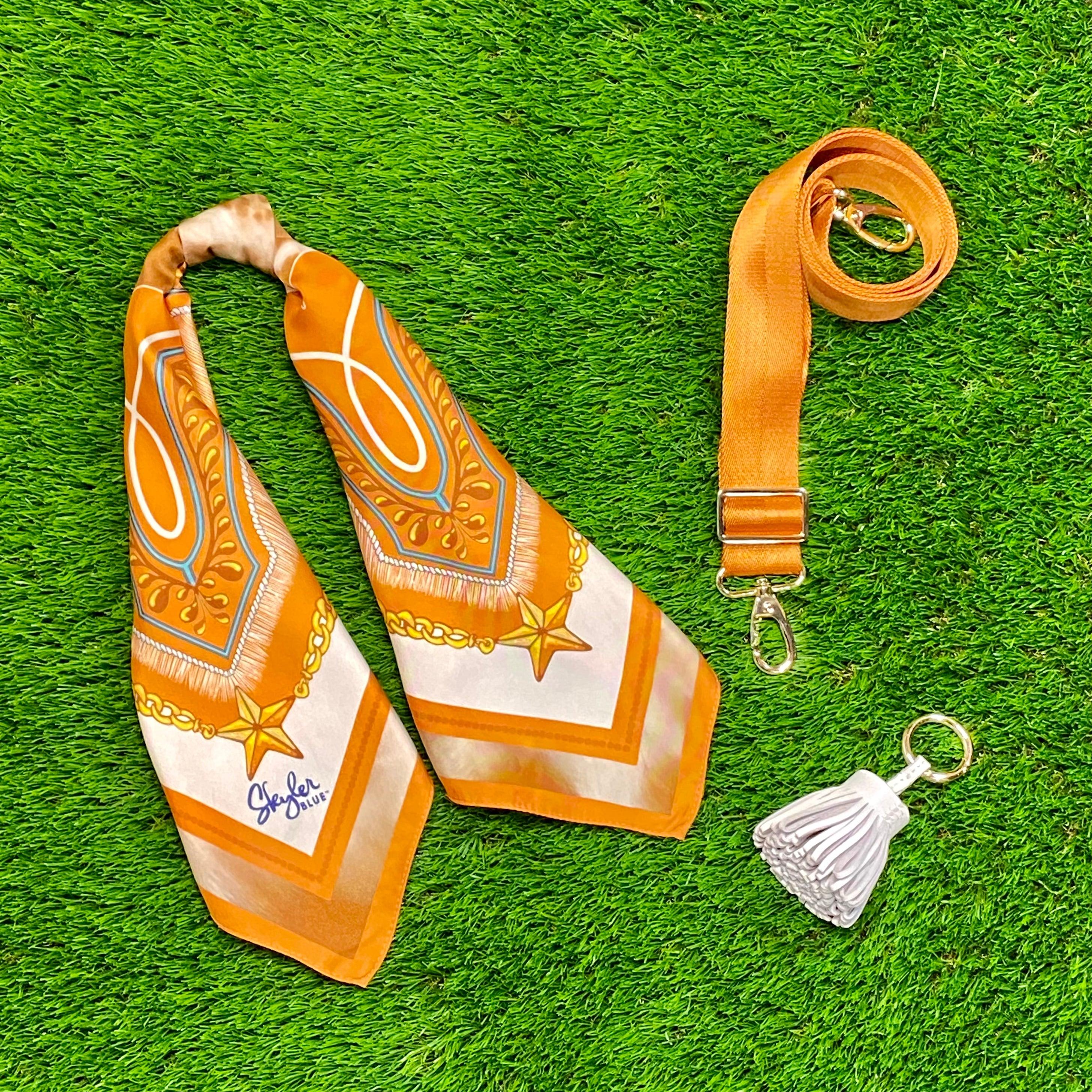 Skyler Blue’s The Austin 001 Accessory Package including adjustable, nylon webbing shoulder or crossbody strap with herringbone weave and gold hardware, 60-centimeter 100% silk twill scarf, and 100% genuine leather tassel.