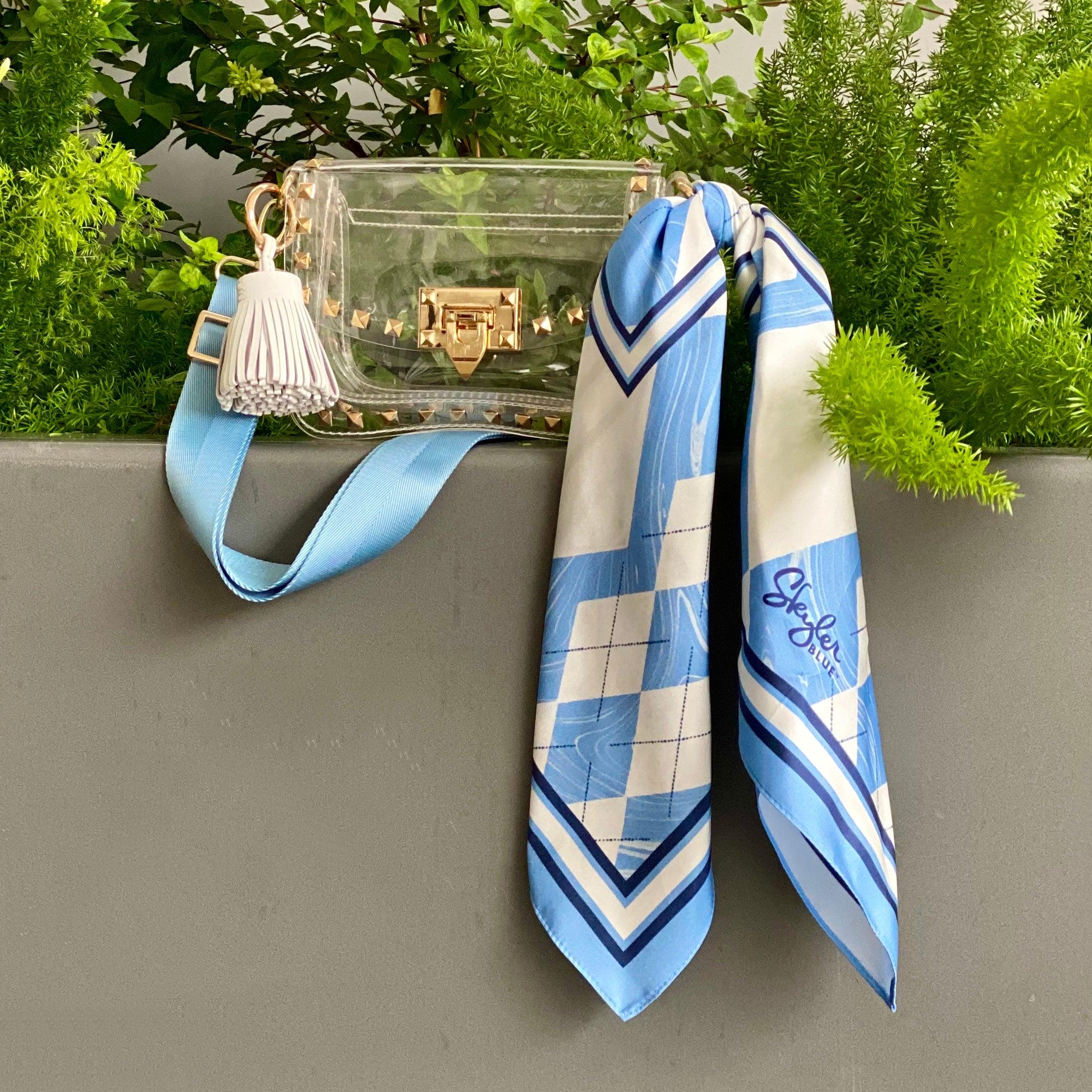 Skyler Blue’s The Chapel Hill Small Studded Clear Bag stadium approved clear bag / clear purse including adjustable, nylon webbing shoulder or crossbody strap with herringbone weave and gold hardware, 60-centimeter 100% silk twill scarf, and 100% genuine leather tassel.