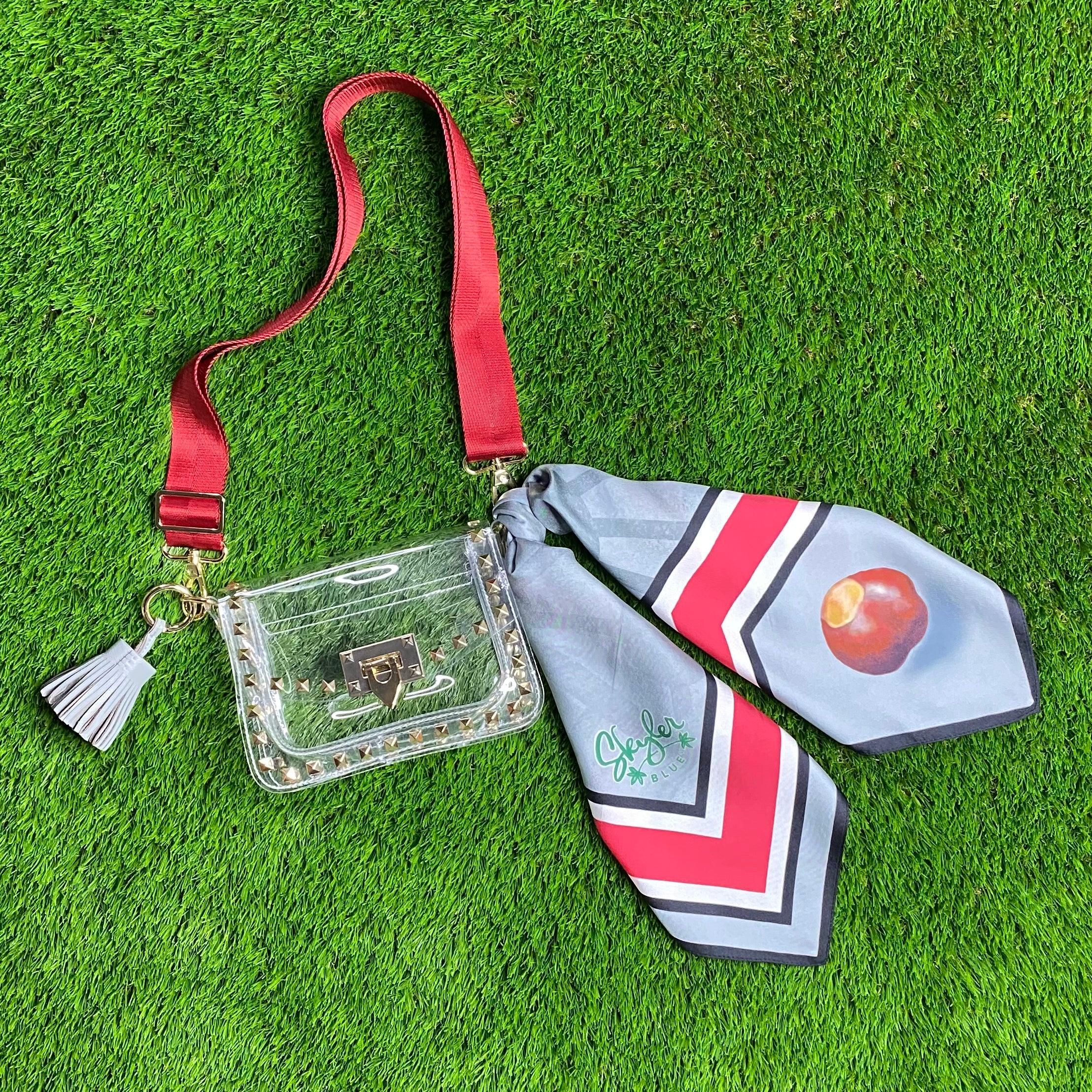 Skyler Blue’s The Columbus Small Studded Clear Bag stadium approved clear bag / clear purse including adjustable, nylon webbing shoulder or crossbody strap with herringbone weave and gold hardware, 60-centimeter 100% silk twill scarf, and 100% genuine leather tassel.