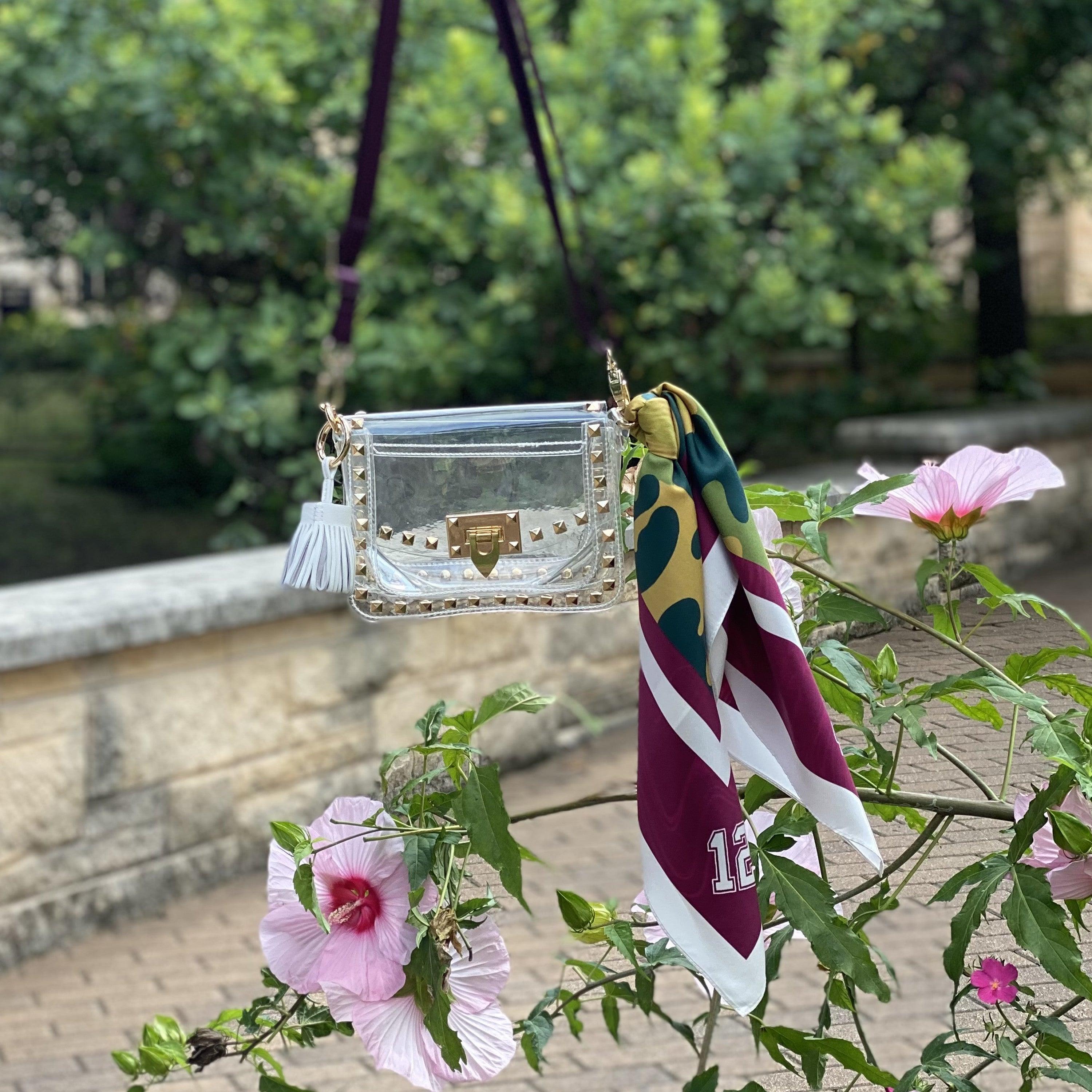 Skyler Blue’s The College Station Small Studded Clear Bag stadium approved clear bag / clear purse including adjustable, nylon webbing shoulder or crossbody strap with herringbone weave and gold hardware, 60-centimeter 100% silk twill scarf, and 100% genuine leather tassel.