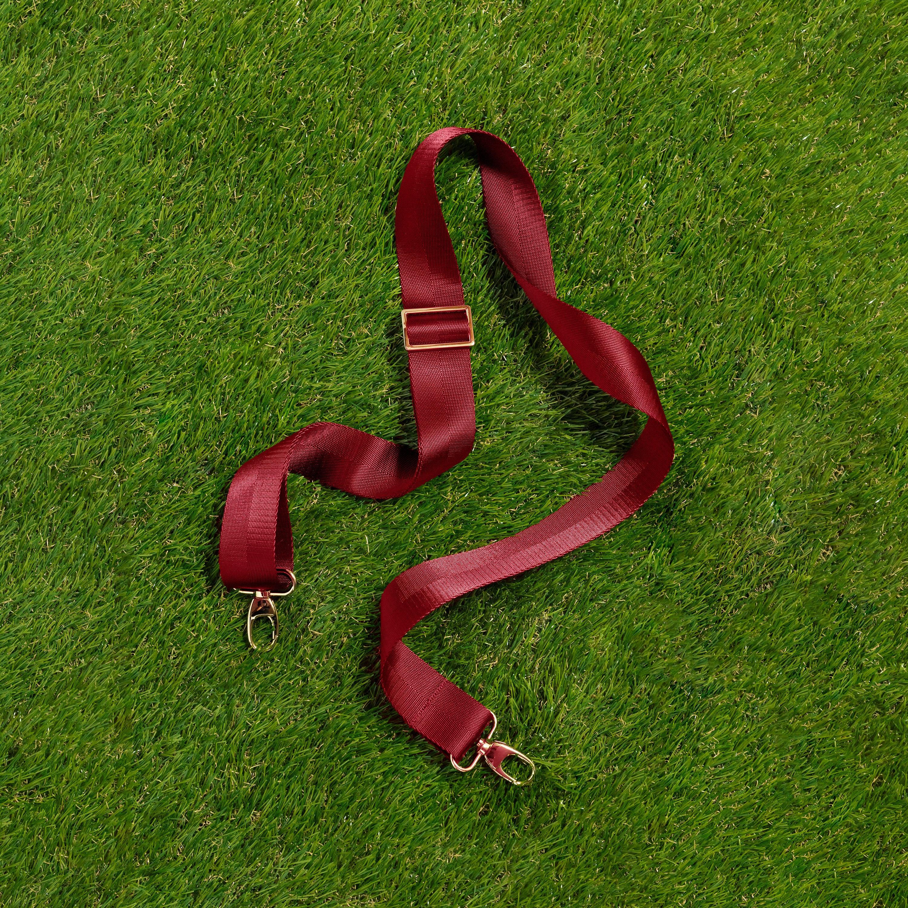 Skyler Blue’s adjustable, nylon webbing garnet red shoulder or crossbody strap with herringbone weave and gold hardware.