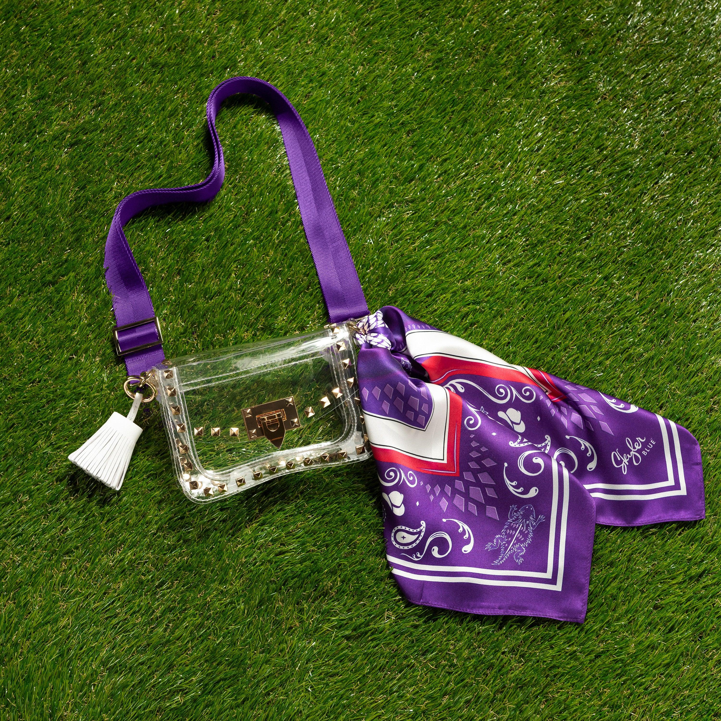 Skyler Blue’s The Fort Worth Small Studded Clear Bag stadium approved clear bag / clear purse including adjustable, nylon webbing shoulder or crossbody strap with herringbone weave and gold hardware, 60-centimeter 100% silk twill scarf, and 100% genuine leather tassel.