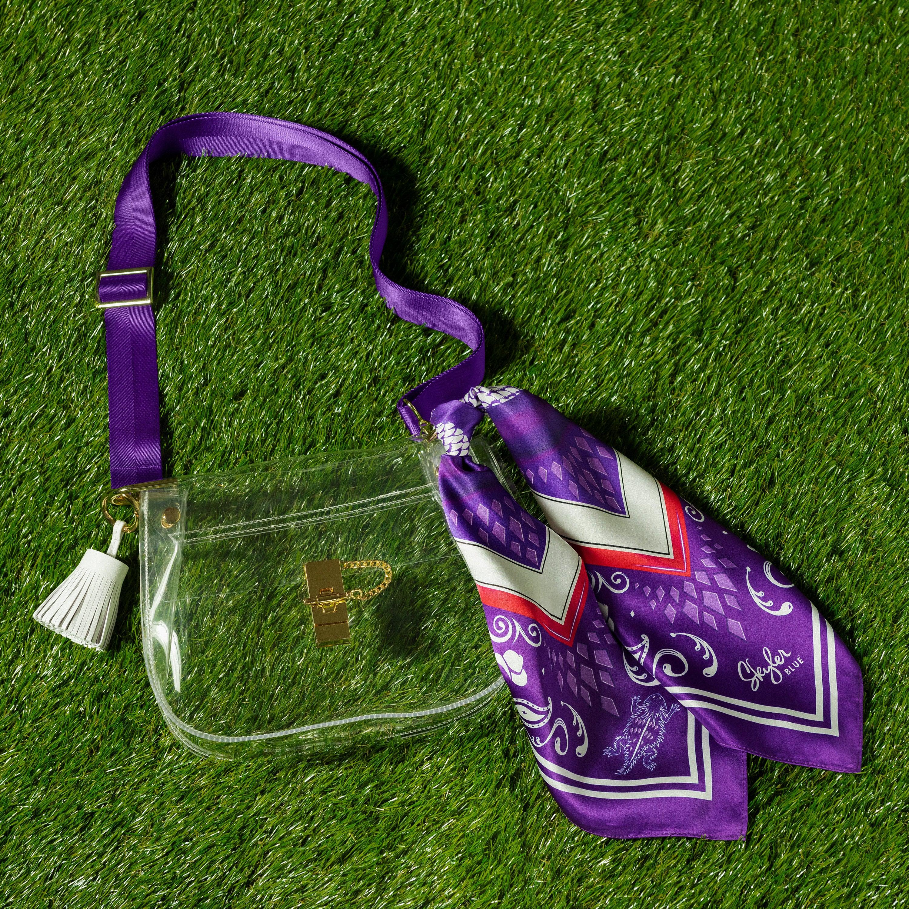 Skyler Blue’s The Fort Worth Medium Saddle Clear Bag stadium approved clear bag / clear purse including adjustable, nylon webbing shoulder or crossbody strap with herringbone weave and gold hardware, 60-centimeter 100% silk twill scarf, and 100% genuine leather tassel.