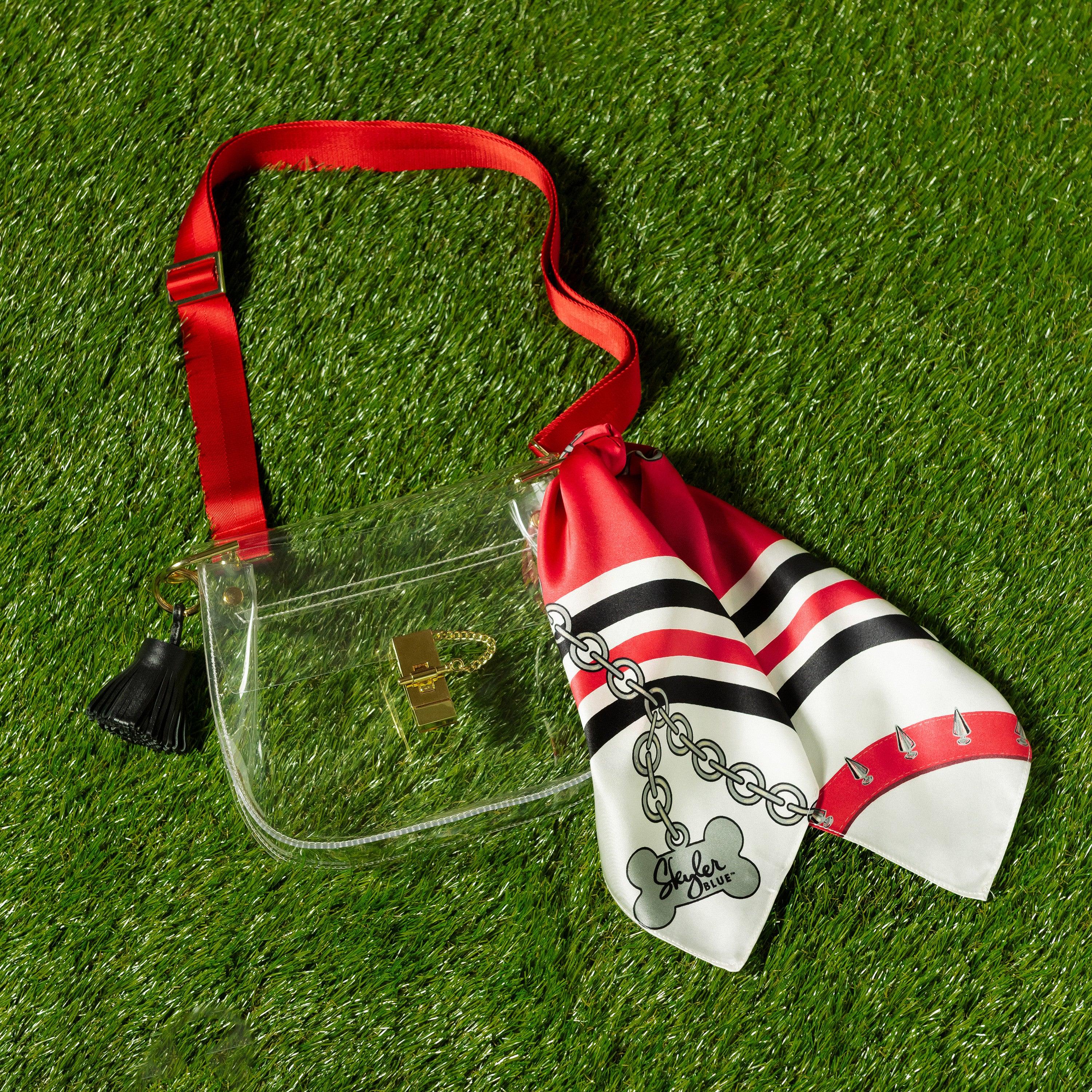 Skyler Blue’s The Athens 001 Medium Saddle Clear Bag stadium approved clear bag / clear purse including adjustable, nylon webbing shoulder or crossbody strap with herringbone weave and gold hardware, 60-centimeter 100% silk twill scarf, and 100% genuine leather tassel.
