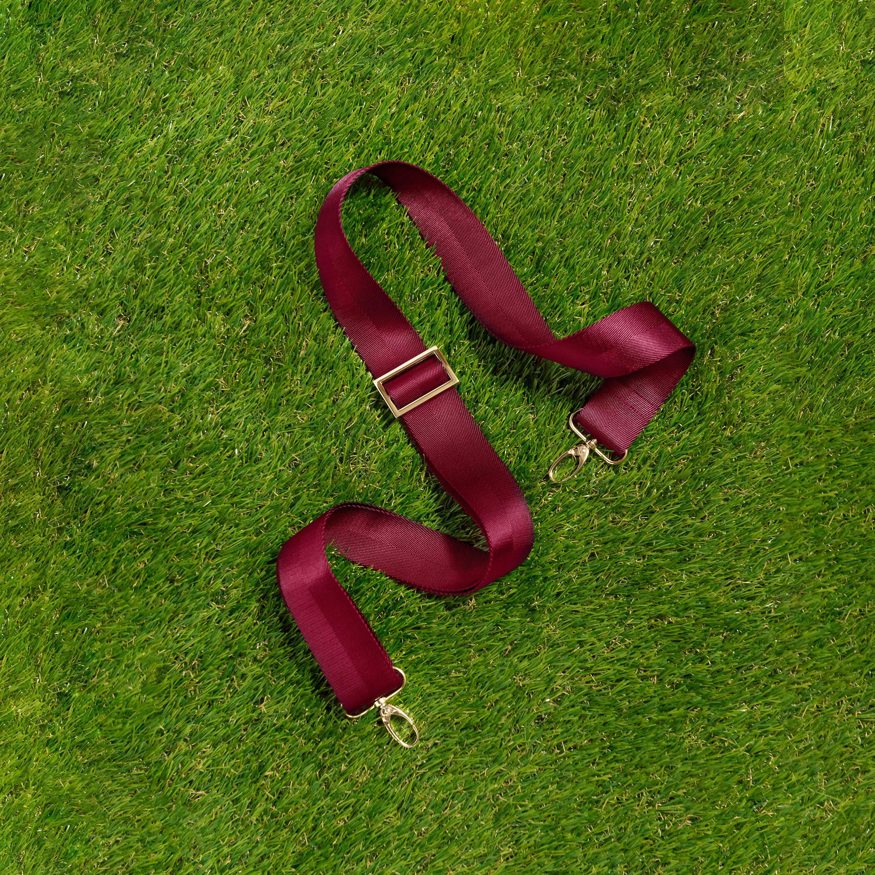 Skyler Blue’s adjustable, nylon webbing maroon shoulder or crossbody strap with herringbone weave and gold hardware.