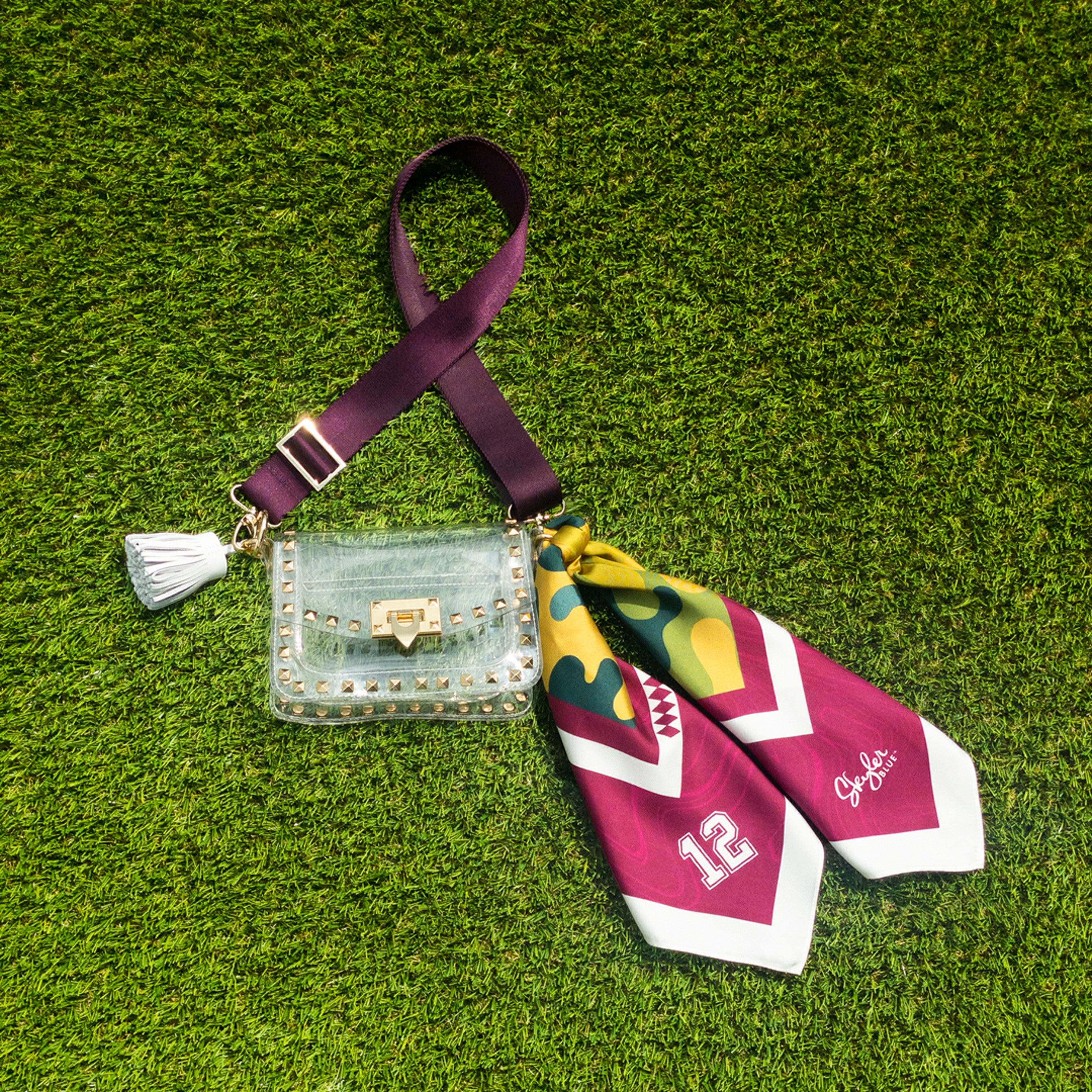 Skyler Blue’s The College Station Small Studded Clear Bag stadium approved clear bag / clear purse including adjustable, nylon webbing shoulder or crossbody strap with herringbone weave and gold hardware, 60-centimeter 100% silk twill scarf, and 100% genuine leather tassel.