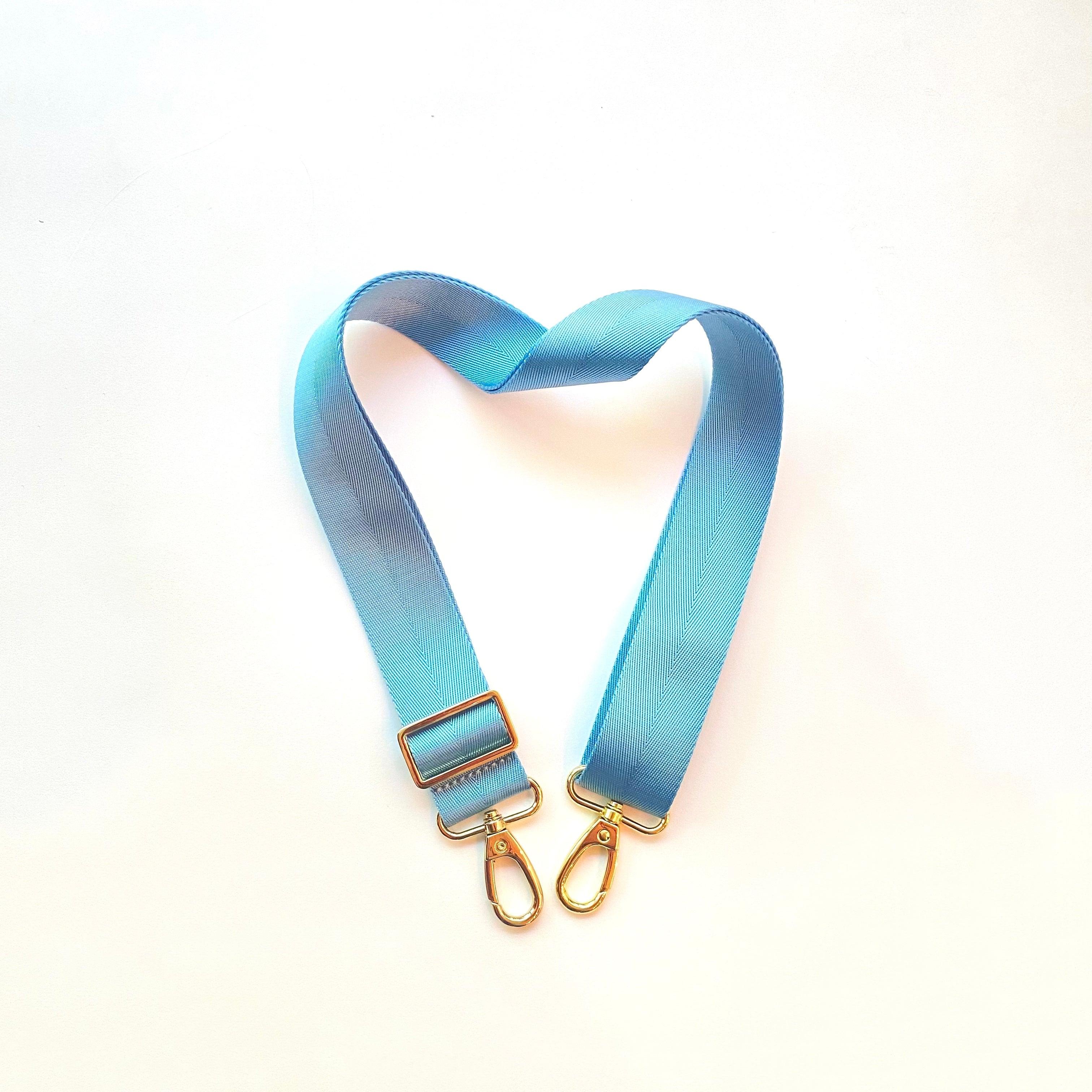 Skyler Blue’s adjustable, nylon webbing powder blue shoulder or crossbody strap with herringbone weave and gold hardware.