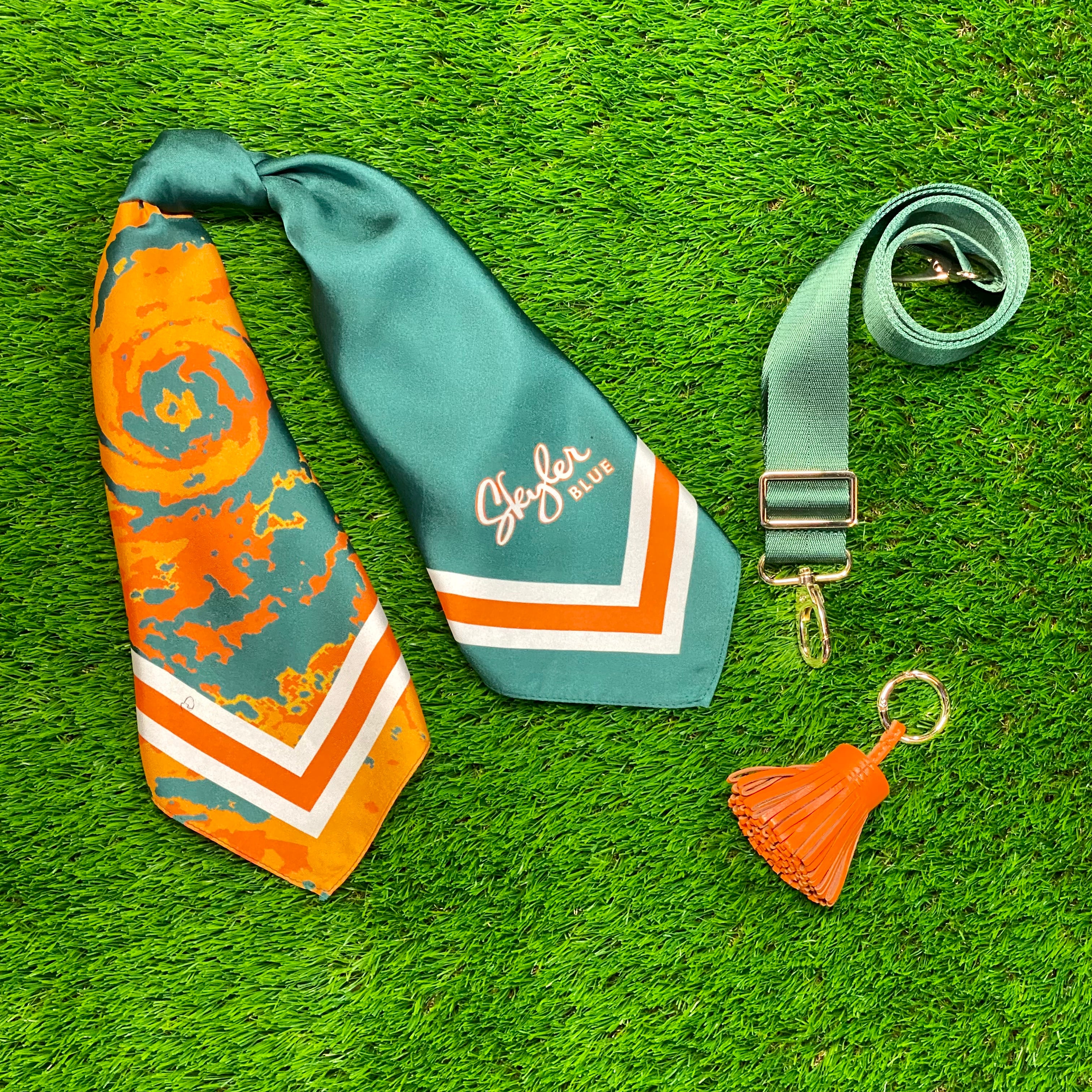 Skyler Blue’s The Coral Gables Accessory Package including adjustable, nylon webbing shoulder or crossbody strap with herringbone weave and gold hardware, 60-centimeter 100% silk twill scarf, and 100% genuine leather tassel.