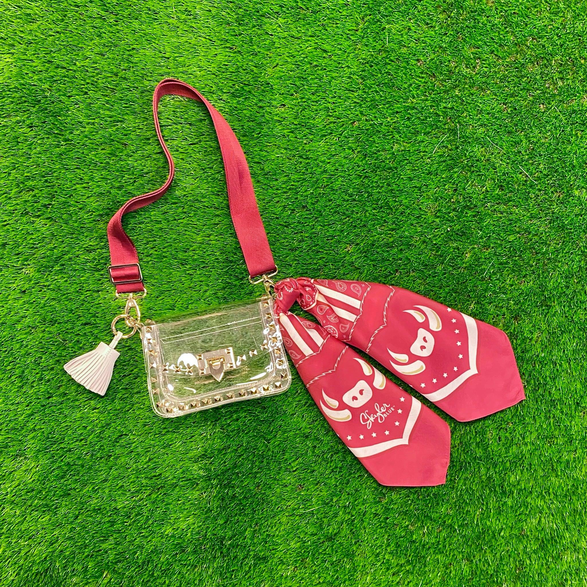 Skyler Blue’s The Fayetteville Small Studded Clear Bag stadium approved clear bag / clear purse including adjustable, nylon webbing shoulder or crossbody strap with herringbone weave and gold hardware, 60-centimeter 100% silk twill scarf, and 100% genuine leather tassel.
