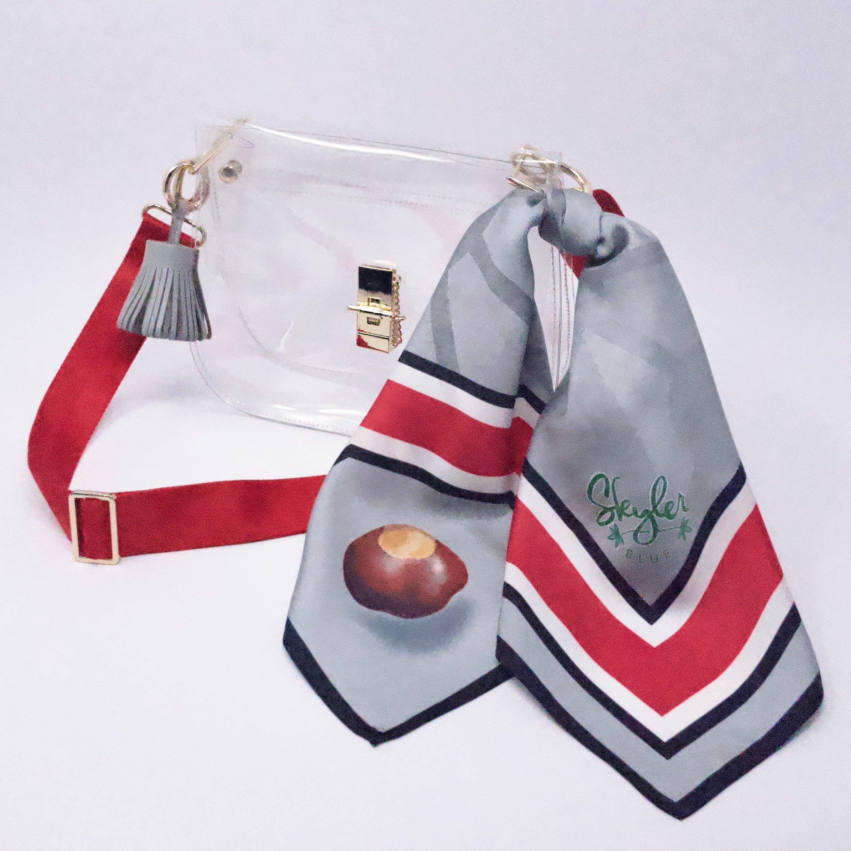 Skyler Blue’s The Columbus Medium Saddle Clear Bag stadium approved clear bag / clear purse including adjustable, nylon webbing shoulder or crossbody strap with herringbone weave and gold hardware, 60-centimeter 100% silk twill scarf, and 100% genuine leather tassel.