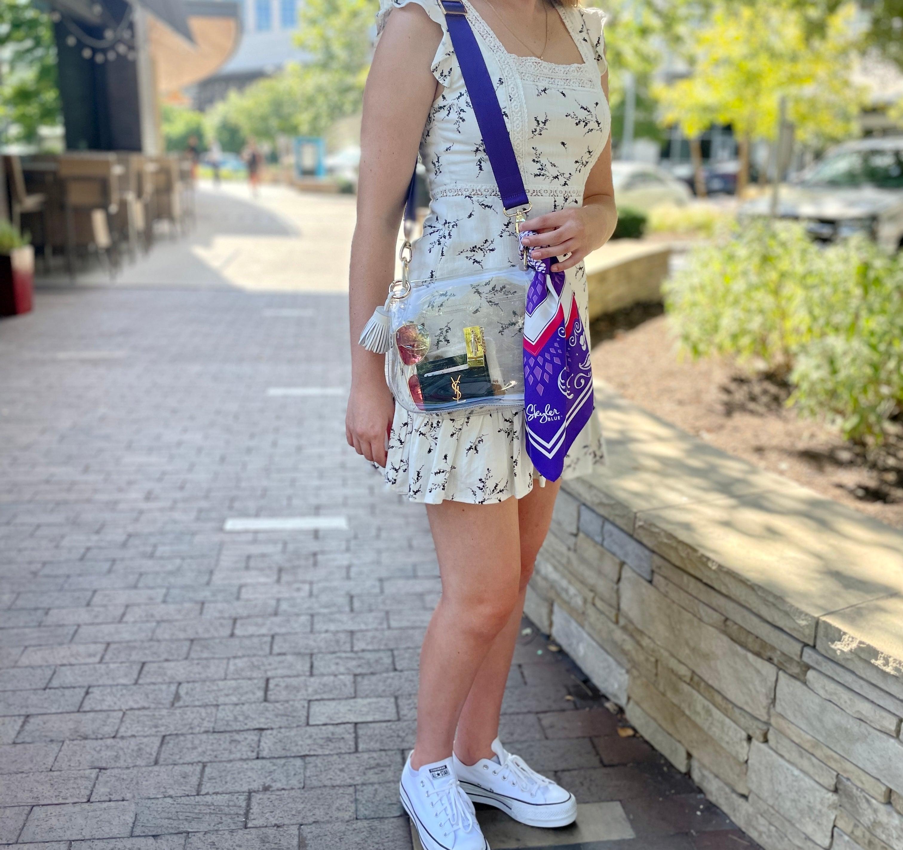 Model wearing Skyler Blue’s The Fort Worth Medium Saddle Clear Bag stadium approved clear bag / clear purse including adjustable, nylon webbing shoulder or crossbody strap with herringbone weave and gold hardware, 60-centimeter 100% silk twill scarf, and 100% genuine leather tassel.