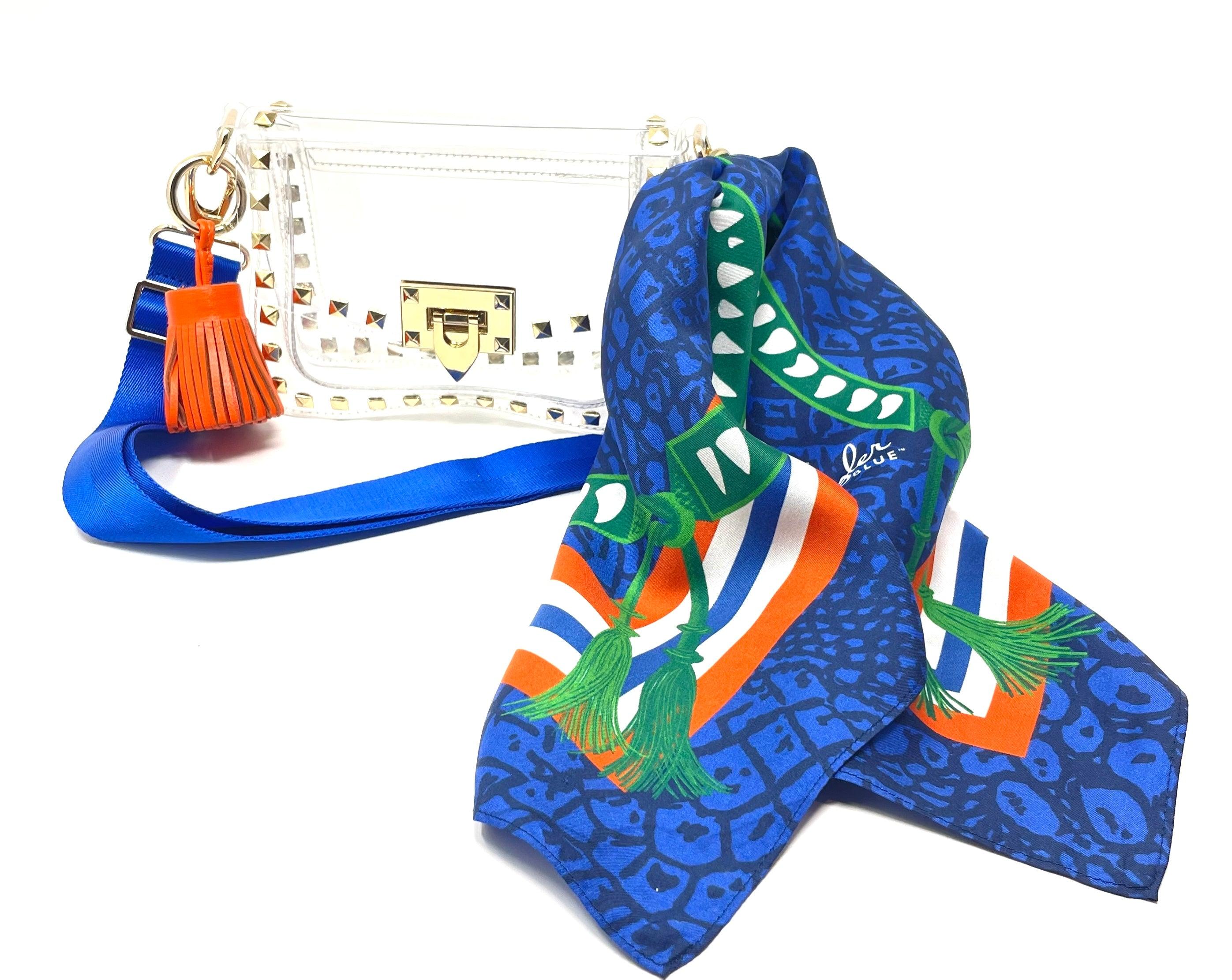 Skyler Blue’s The Gainesville Small Studded Clear Bag stadium approved clear bag / clear purse including adjustable, nylon webbing shoulder or crossbody strap with herringbone weave and gold hardware, 60-centimeter 100% silk twill scarf, and 100% genuine leather tassel.