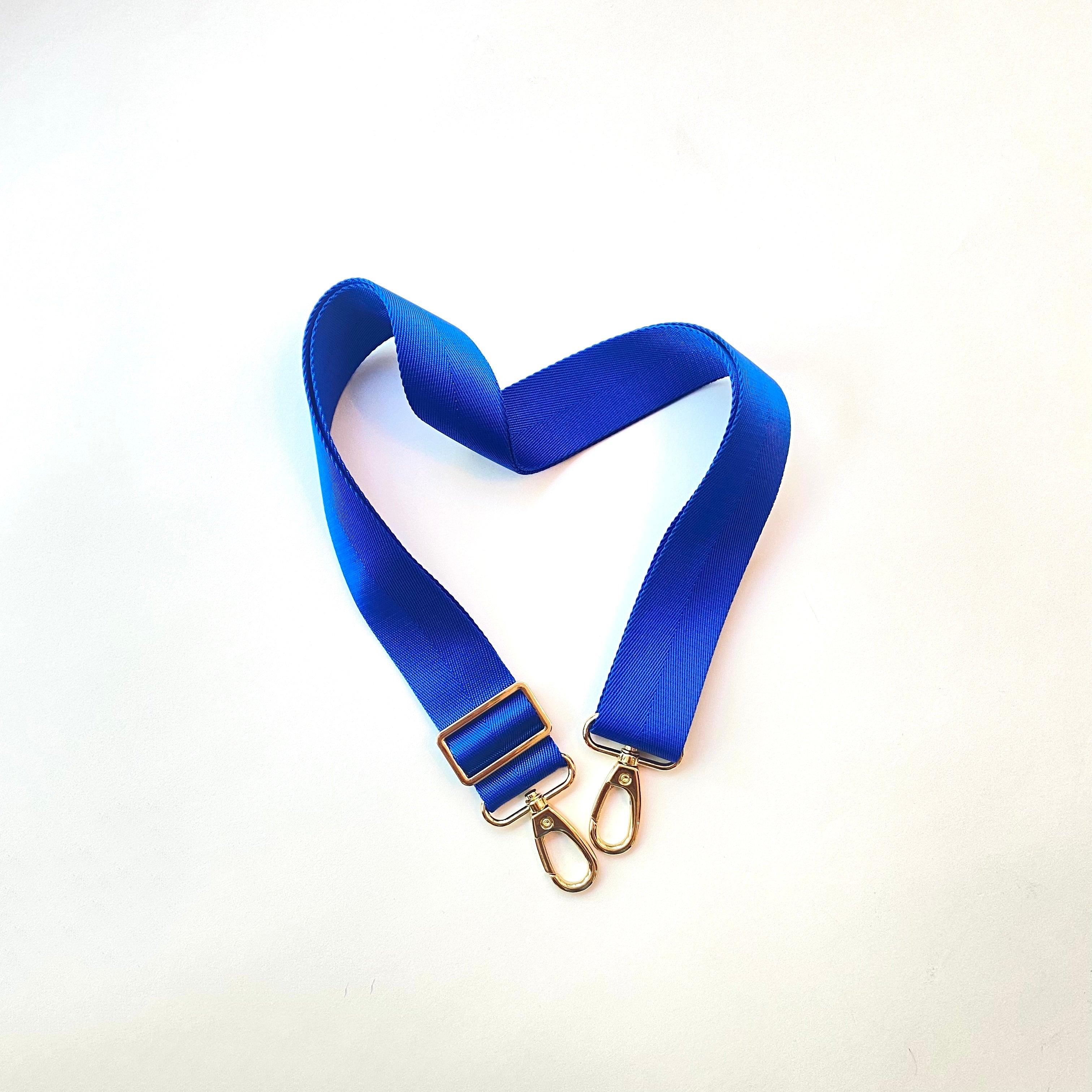 Skyler Blue’s adjustable, nylon webbing royal blue shoulder or crossbody strap with herringbone weave and gold hardware.