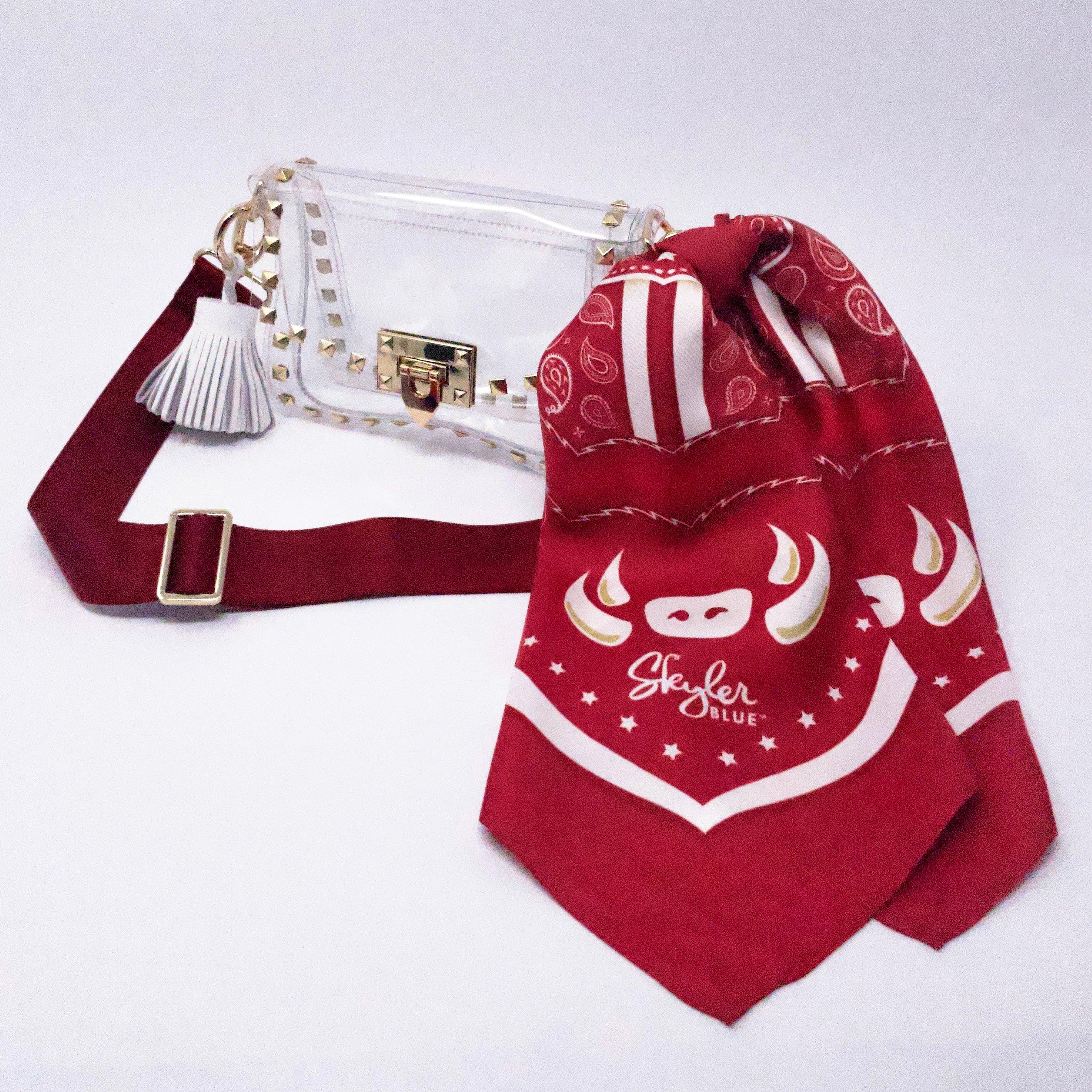 Skyler Blue’s The Fayetteville Small Studded Clear Bag stadium approved clear bag / clear purse including adjustable, nylon webbing shoulder or crossbody strap with herringbone weave and gold hardware, 60-centimeter 100% silk twill scarf, and 100% genuine leather tassel.