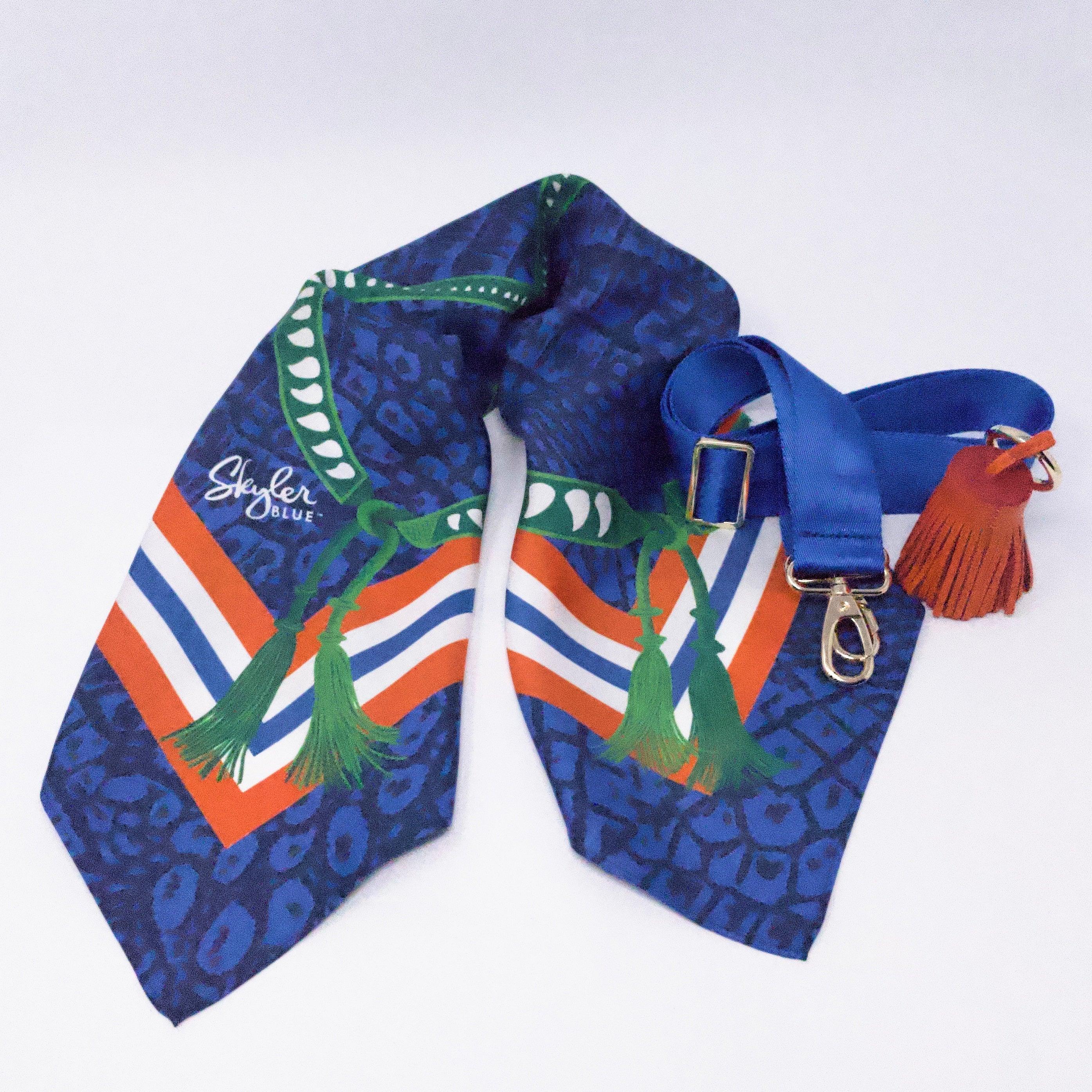 Skyler Blue’s The Gainesville Accessory Package including adjustable, nylon webbing shoulder or crossbody strap with herringbone weave and gold hardware, 60-centimeter 100% silk twill scarf, and 100% genuine leather tassel.