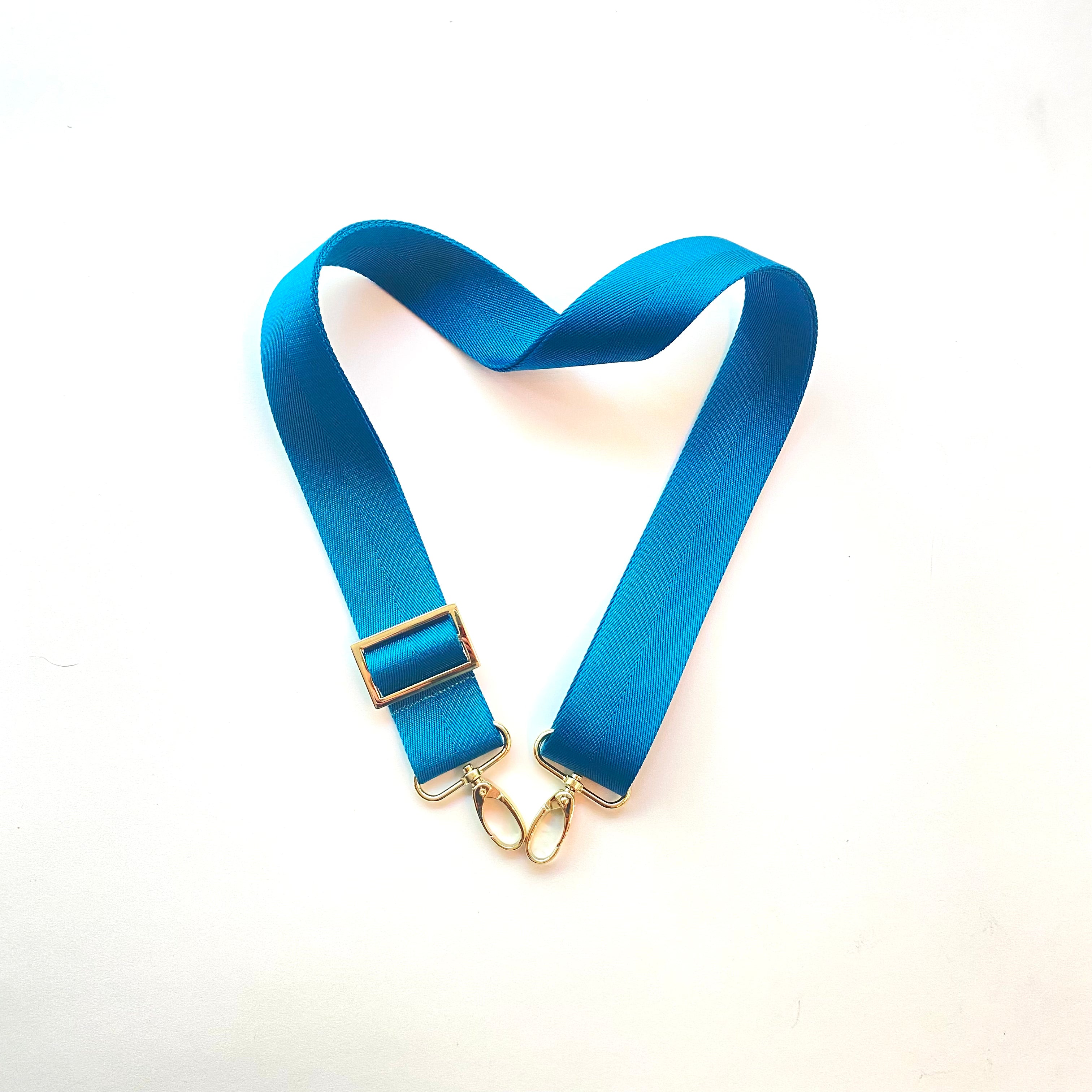 Skyler Blue’s adjustable, nylon webbing teal shoulder or crossbody strap with herringbone weave and gold hardware.