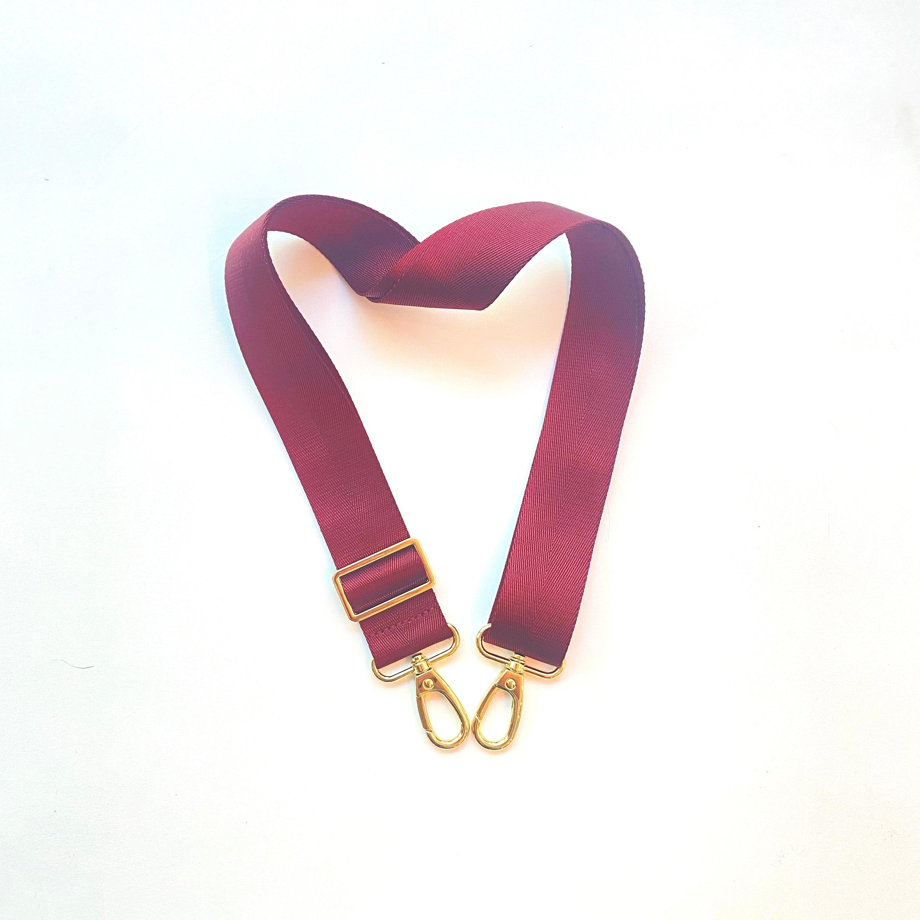 Skyler Blue’s adjustable, nylon webbing garnet red shoulder or crossbody strap with herringbone weave and gold hardware.