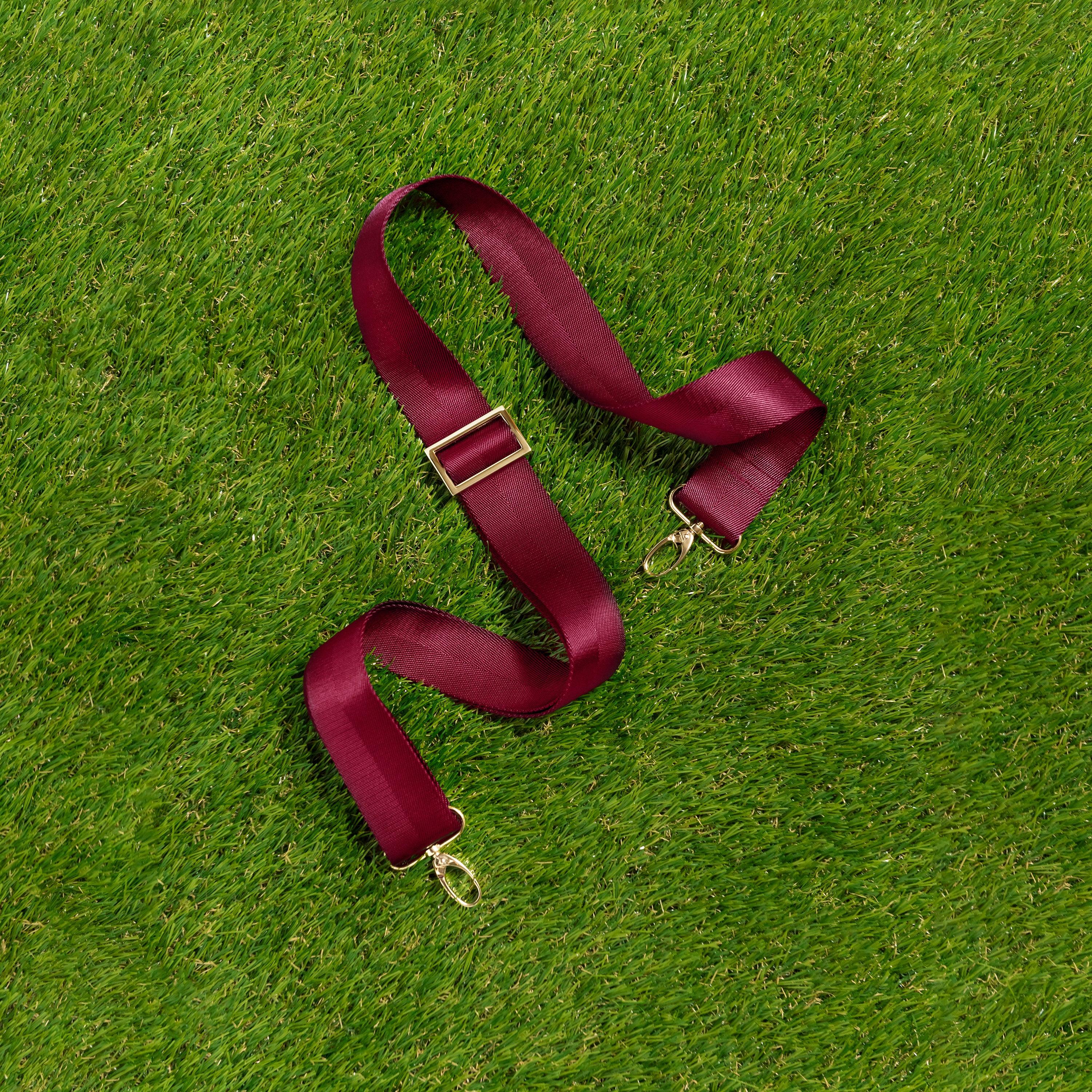 Skyler Blue’s adjustable, nylon webbing maroon shoulder or crossbody strap with herringbone weave and gold hardware.