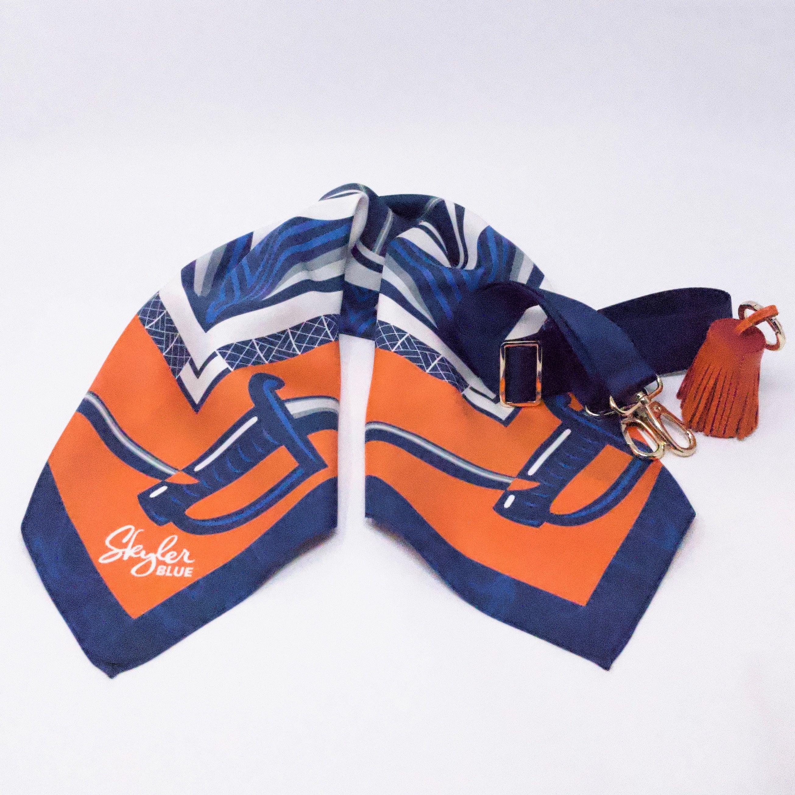 Skyler Blue’s The Charlottesville Accessory Package including adjustable, nylon webbing shoulder or crossbody strap with herringbone weave and gold hardware, 60-centimeter 100% silk twill scarf, and 100% genuine leather tassel.