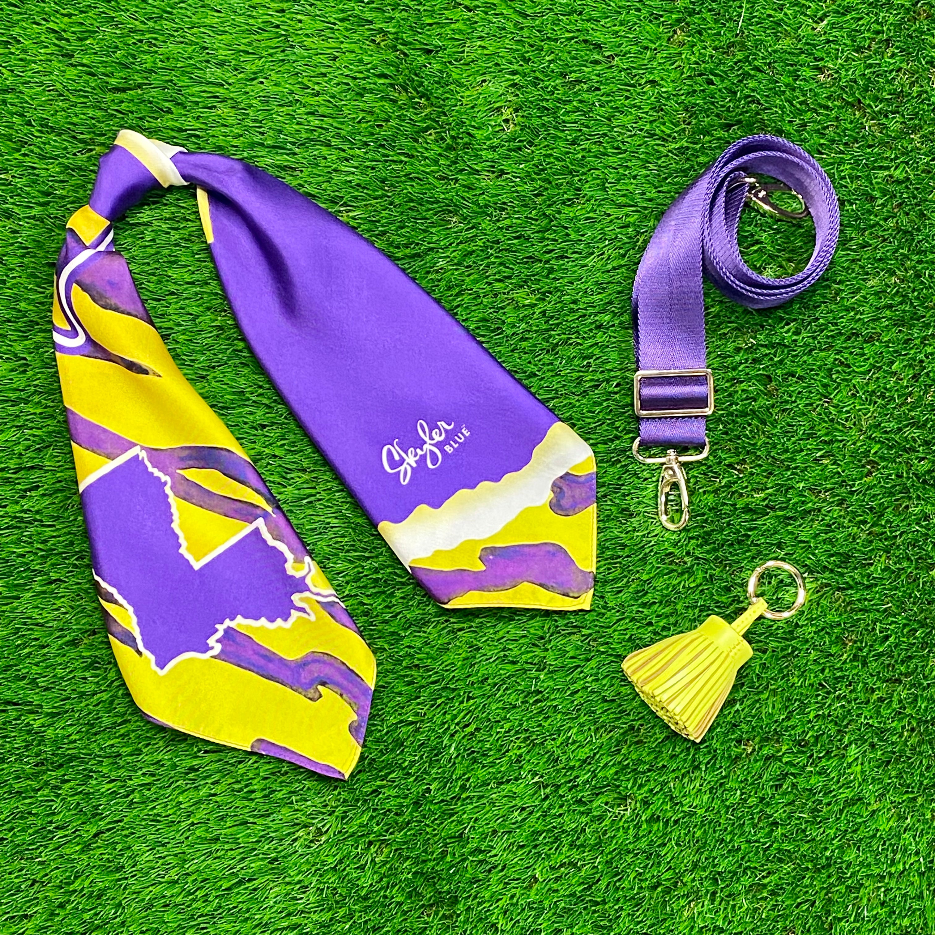 Skyler Blue’s The Baton Rouge Accessory Package including adjustable, nylon webbing shoulder or crossbody strap with herringbone weave and gold hardware, 60-centimeter 100% silk twill scarf, and 100% genuine leather tassel.