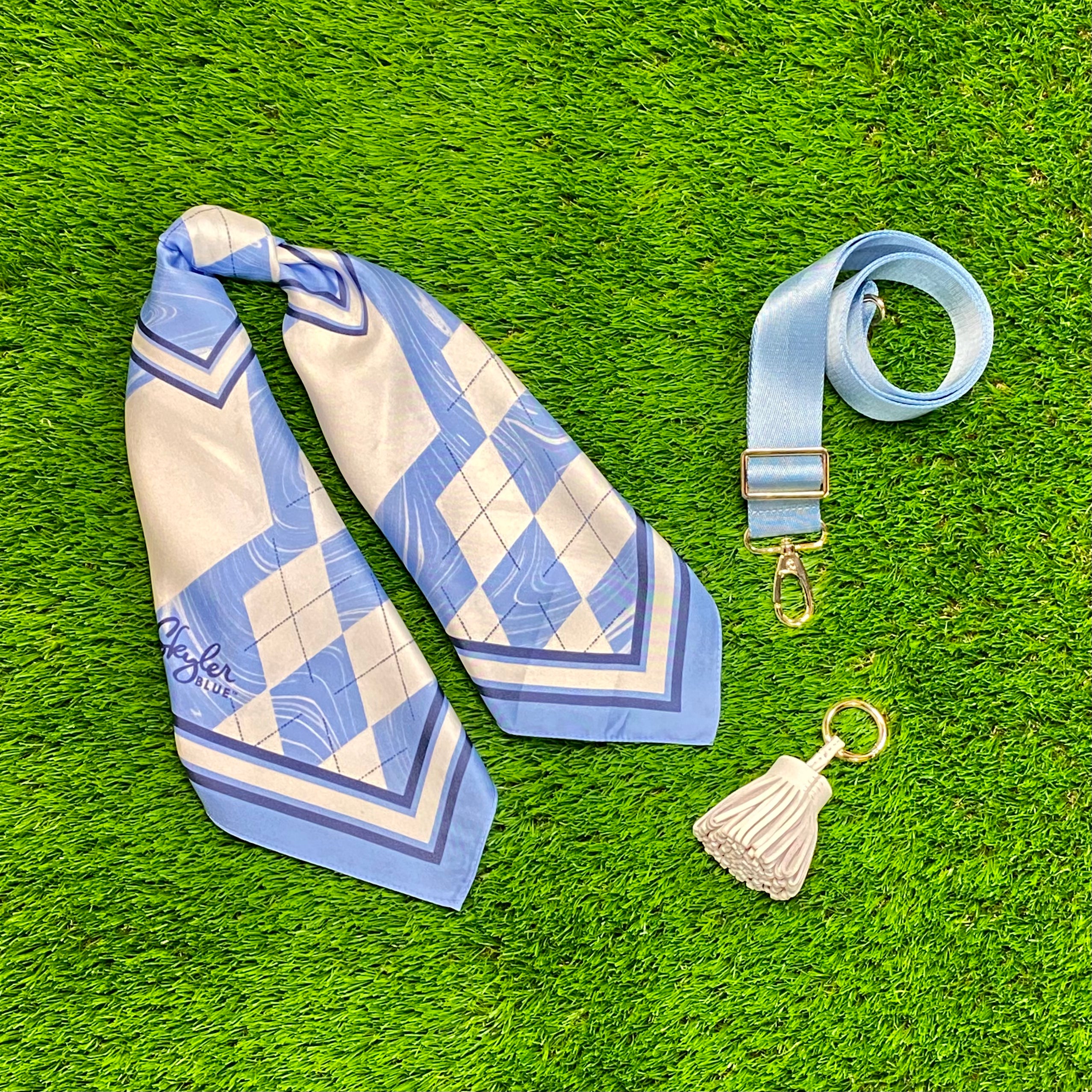 Skyler Blue’s The Chapel Hill Accessory Package including adjustable, nylon webbing shoulder or crossbody strap with herringbone weave and gold hardware, 60-centimeter 100% silk twill scarf, and 100% genuine leather tassel. 