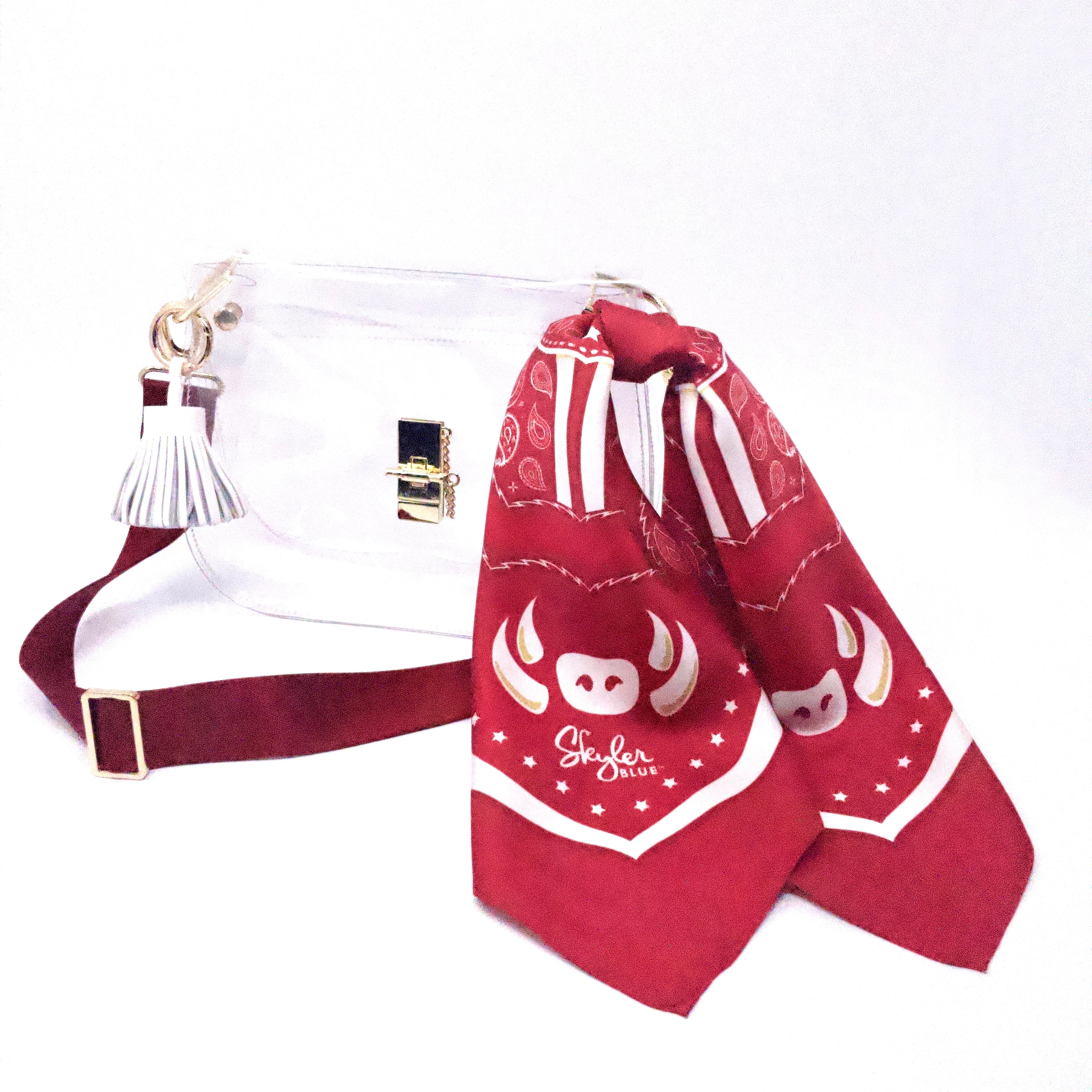 Skyler Blue’s The Fayetteville Medium Saddle Clear Bag stadium approved clear bag / clear purse including adjustable, nylon webbing shoulder or crossbody strap with herringbone weave and gold hardware, 60-centimeter 100% silk twill scarf, and 100% genuine leather tassel. 
