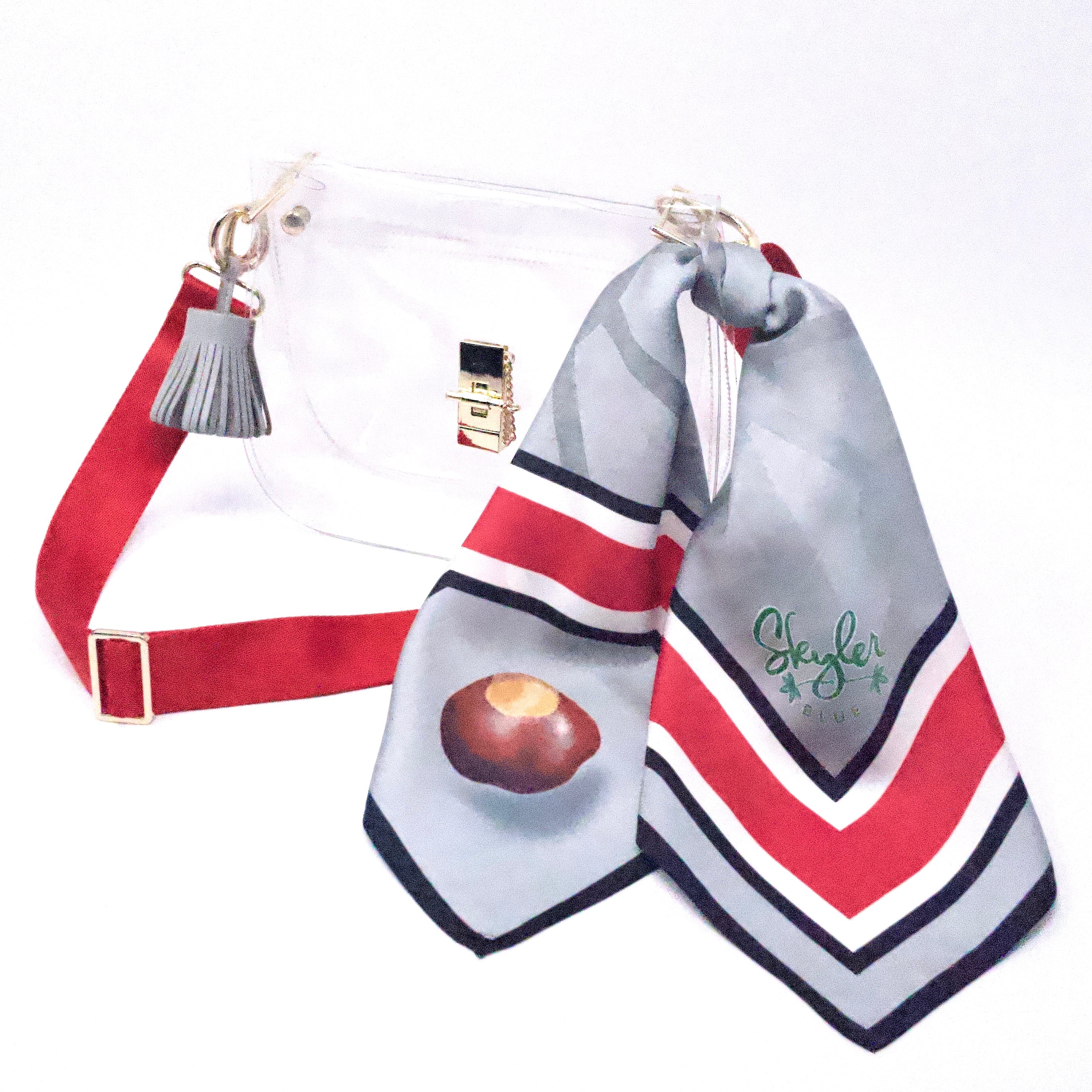 Skyler Blue’s The Columbus Medium Saddle Clear Bag stadium approved clear bag / clear purse including adjustable, nylon webbing shoulder or crossbody strap with herringbone weave and gold hardware, 60-centimeter 100% silk twill scarf, and 100% genuine leather tassel. 